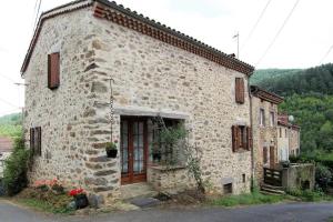 a stone building with a door on the side of it at Charmante maison à la campagne près d'une ferme in Saint-Cirgues