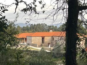 an old stone building with an orange roof at Quinta Pazo Corisca in Salceda