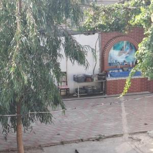 a brick patio with a brick fireplace and a tree at House Near Baku Airport and BOS in Baku