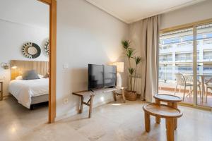 a bedroom with a bed and a tv and a mirror at Hauzify I Apartament Michelangelo in Salou