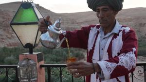 a man is holding a drink with a street light at ACHAHOUD CHEz LA BELLE FIBULLE in Aït Fars
