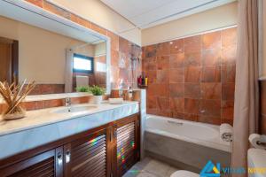 łazienka z umywalką, wanną i lustrem w obiekcie Casa Bonita - LH144 By Villas Now Ltd w mieście Playa Blanca