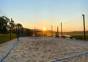 a volleyball court with the sunset in the background at Hotel Chalé Capitólio in Capitólio