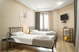 a hotel room with two beds and a tv at Monument1880 in Tbilisi City