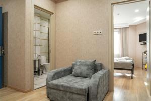 a living room with a chair and a bedroom at Monument1880 in Tbilisi City