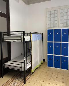Pokój z 2 łóżkami piętrowymi i niebieskimi szafkami w obiekcie The Cathedral Hostel w Murcji
