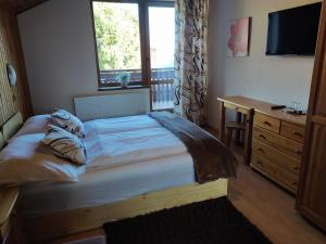 a bedroom with a bed and a desk and a window at Privat Jasmin in Mengusovce