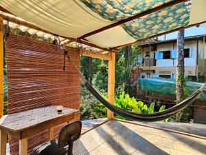 a hammock on a patio with a view of a building at Eco Hostel Bosque di Barro in Ilha de Boipeba