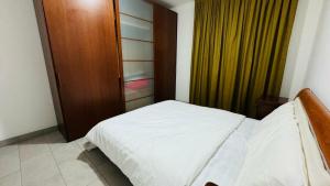 a bedroom with a white bed and a wooden door at Matis Appartamenti in Camisano