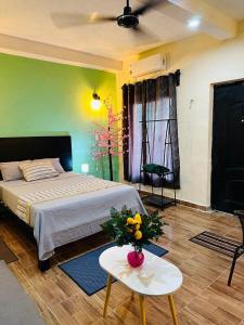 a bedroom with a bed and a table with flowers on it at Casita Salome in Valladolid