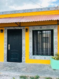 a yellow and white house with a black door at Casita Salome in Valladolid