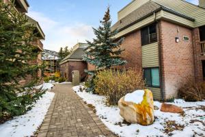 a brick house with a snow covered driveway at Silvertown Condos by Park City Vacations in Park City