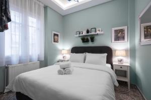 a bedroom with a white bed and a window at Homevision - Architectural Condo in Thessaloniki