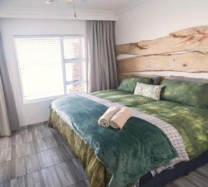 a bedroom with a bed with two towels on it at The Ark Guesthouse at Marina Martinique in Jeffreys Bay