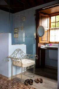 ein Badezimmer mit einer Bank, einem Spiegel und einigen Schuhen in der Unterkunft Haciendas del Valle-Montemayor in Las Toscas