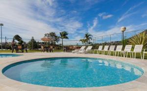 a large swimming pool with chairs and a table at Hotel Nascentes da Serra in Poços de Caldas