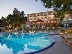 a hotel with a pool in front of a building at Xenia Palace Portaria in Portaria