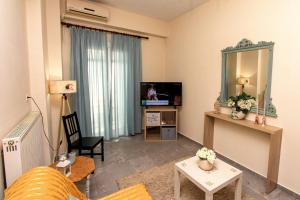 a living room with a couch and a television at Κεντρικό ρομαντικό άνετο σπίτι in Ámfissa