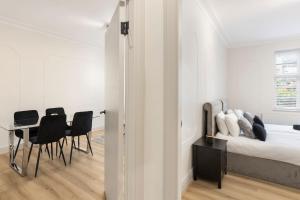 a bedroom with a bed and a table and chairs at Cozy and spacious full size flat in London +11 photos
