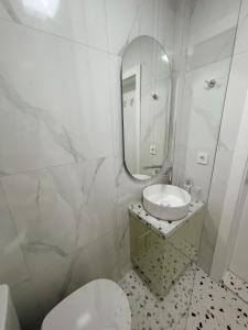 Un baño con inodoro, lavabo y espejo. en Ella Lux Apartment, en Skopje 14 fotos más