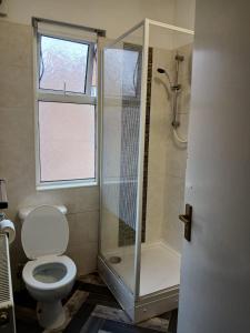 a bathroom with a shower and a toilet and a window at DB Room near NTU city Campus in Nottingham