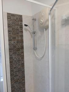 a shower in a bathroom with a glass door at DB Room near NTU city Campus in Nottingham