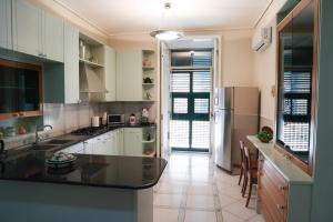 Una cocina con gabinetes blancos y una encimera negra. en Stabiae luxury guest house, en Castellammare di Stabia