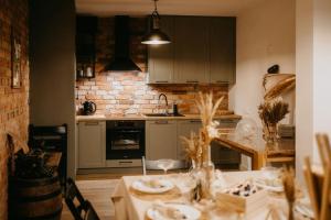a kitchen with a table and a brick wall at Murowana GlinCa in Żelewo