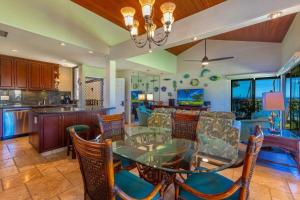 a dining room with a glass table and chairs at WAILEA ELUA, #1302 condo in Wailea +30 photos