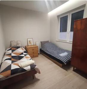 a bedroom with two beds and a window at Oaza Spokoju in Wólka Iłowiecka