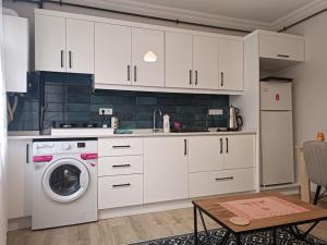 a kitchen with white cabinets and a washing machine at Evinizin Konforunu Yaşayın ! in Istanbul