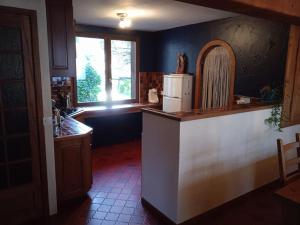a kitchen with a counter with a refrigerator and a window at L'Aussoyenne in Aussois
