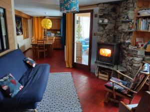 a living room with a blue couch and a stone fireplace at L'Aussoyenne in Aussois