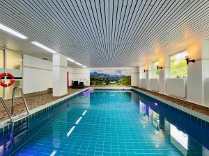 a swimming pool with a blue tile floor and a ceiling at Zickenstüble B19 Montana Haus in Oberstdorf