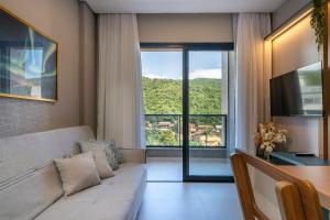 a living room with a couch and a large window at Sunny Flats in Bombas