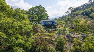 a glass house on the side of a mountain at Colores de la Sierra in Minca
