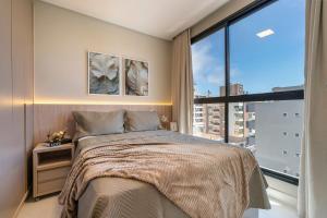 a bedroom with a bed and a large window at Sunny Flats in Bombas +245 photos