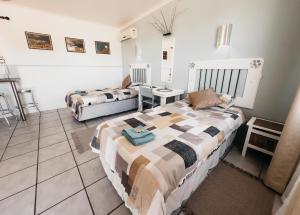 a bedroom with two beds and a table in it at Lekkerbly Self Catering in Pofadder
