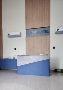a lobby of a hotel with a sign on the wall at Luster Hotel in João Câmara