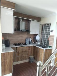 a kitchen with wooden cabinets and a counter top at AK Homes in Rāwāt