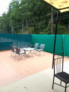 a group of chairs and a table on a tennis court at AK Homes in Rāwāt