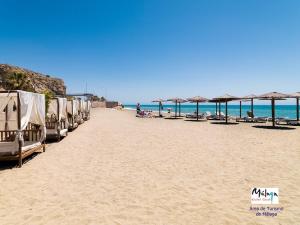 a row of umbrellas on a beach with the ocean at Apartamento Boho en El Soho de Málaga in Málaga