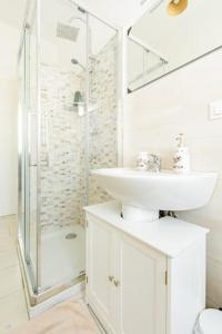 a white bathroom with a sink and a shower at La finestra sulla fiera in Bologna +21 photos