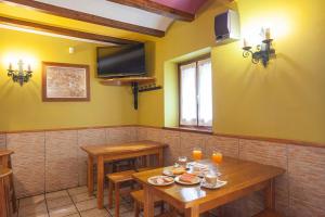 a dining room with two tables and a television at CASA RURAL BARAZAR in San Sebastián