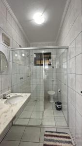 Un baño con ducha, lavabo e inodoro. en Casa c piscina a 700m da Praia de Caraguatatuba SP, en Caraguatatuba 35 fotos más