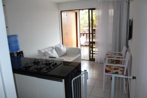 cocina con fogones y sofá en una habitación en Nannai Residence - Flat em Muro Alto, en Porto de Galinhas