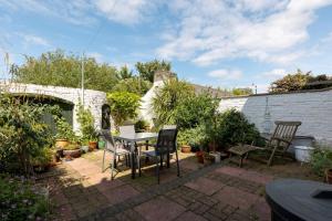 a patio with a table and chairs in a garden at 3BD Victorian Townhouse Near Norfolk Broads 4A, 2C in Beccles