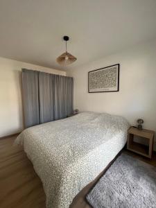 a bedroom with a bed with a white comforter at Spacieux et confortable - centre ville de BRIANCON - SERRE-CHEVALIER - Garage et Wifi in Briançon