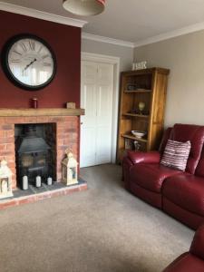 a living room with a couch and a clock on the wall at Cosy House in Lovely Market Town in Newport +7 photos