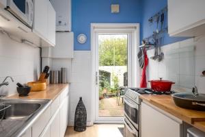 a kitchen with a sink and a stove top oven at 3BD Victorian Townhouse Near Norfolk Broads 4A, 2C in Beccles